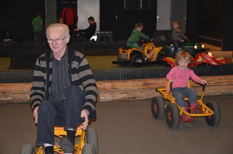 Billede af en ældre herre og en lille pige der kører moon-car