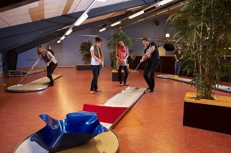et flok unge mennesker der spiller minigolf